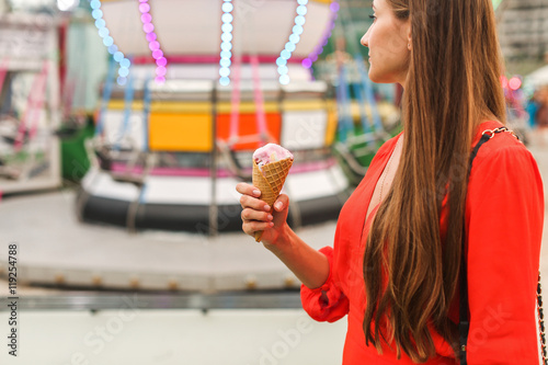 girl in amusement park eating ice cream