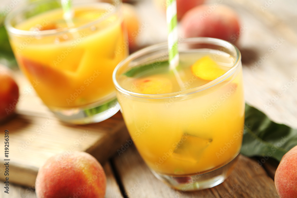 Fototapeta premium Glasses of peach juice on grey wooden table