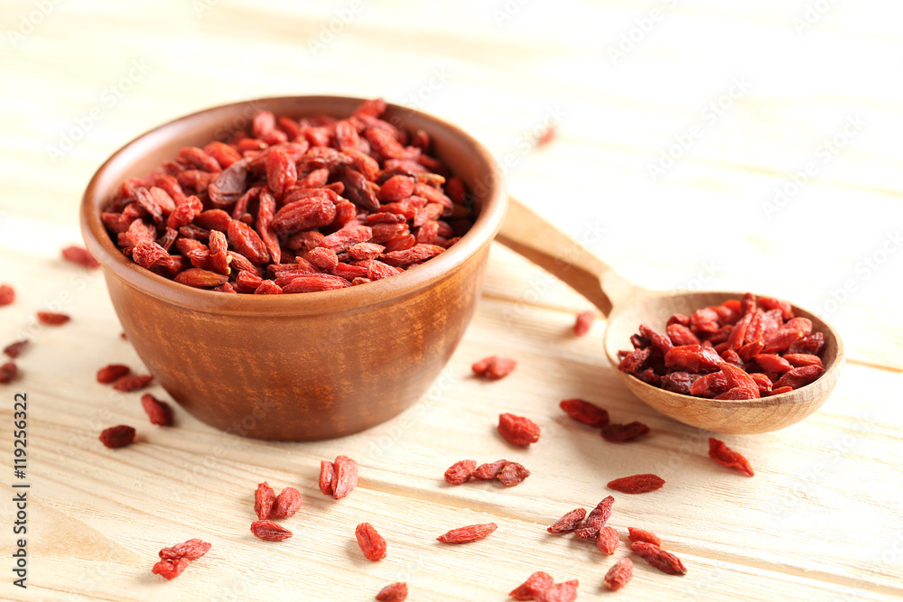 Dry goji berries on beige wooden table