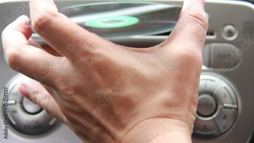 Asian Man Hand Insert Music CD Into Car Music Player