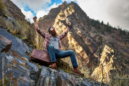 screaming bearded hipster gloating over mountain climb photo