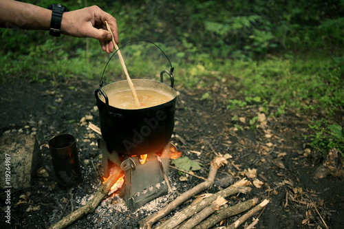 Man cooking on fire in forest