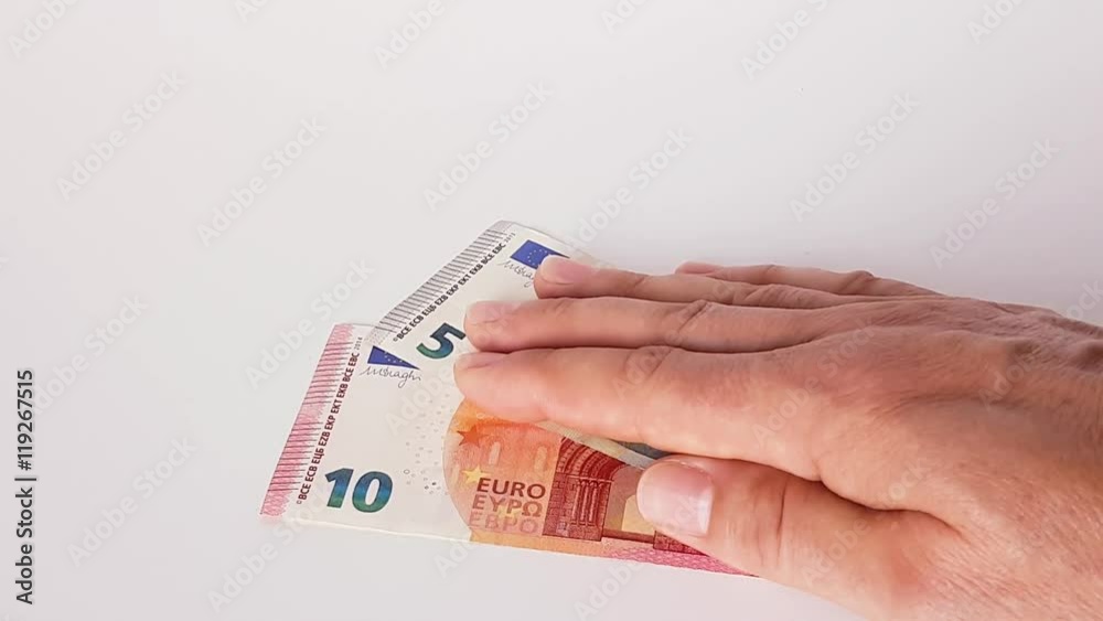 15 Euro werden von einer männlichen Hand auf einen Tisch geschoben