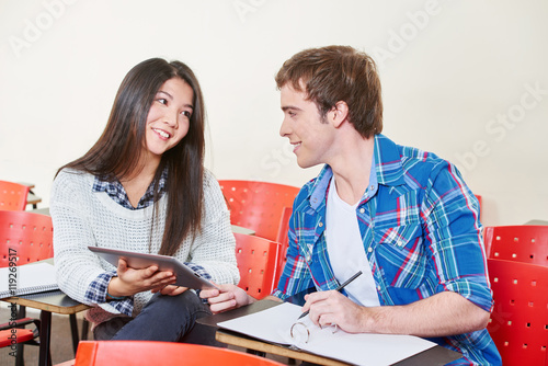 Zwei Studenten mit Tablet flirten sich an