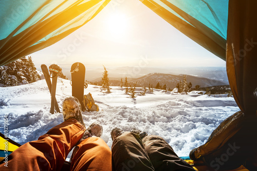 Couple of snowboarder and skier in tent