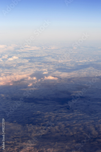 Fluffy clouds over the earth, the landscape. The scenic sky during sunset, the view from the air.