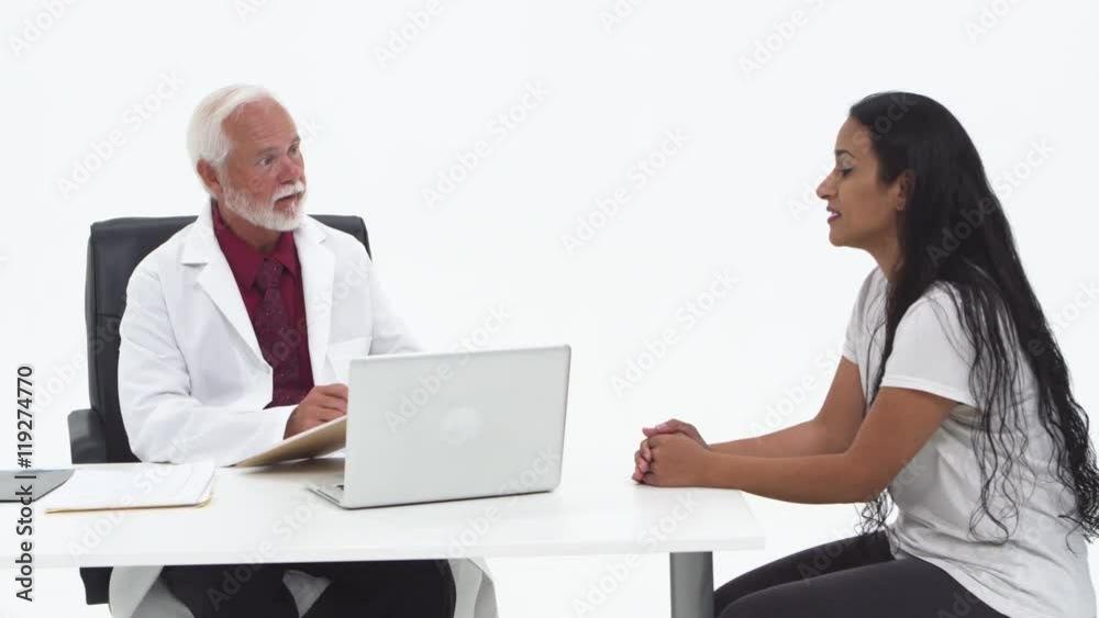Doctor taking notes and speaking to patient Doctor taking notes and speaking to patient