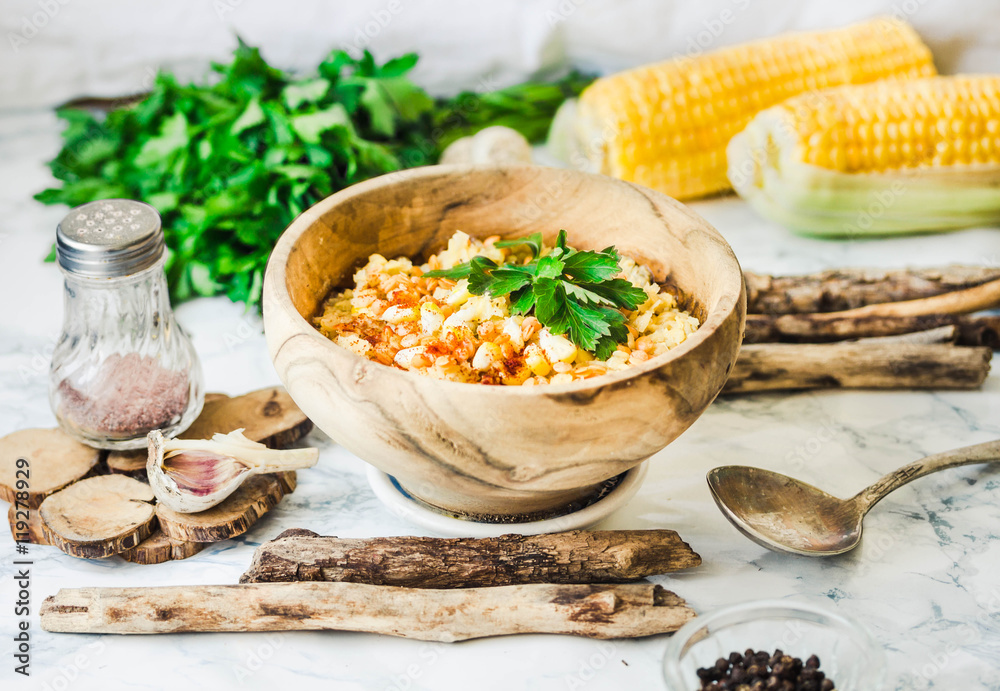 red lentil soup with corn, paprika and herbs in wooden plate red lentil soup with corn, paprika and herbs in wooden plate