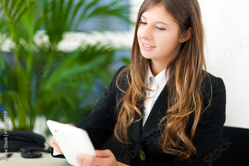 Youngn businesswoman using her tablet computer in the office photo