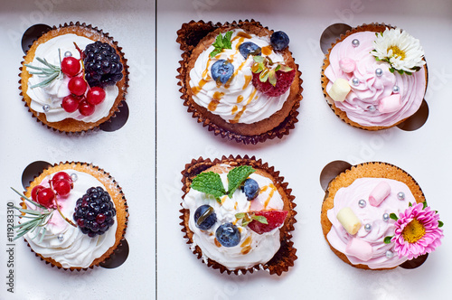 Sweet cakes / cupcakes with fresh flowers, berries, marshmallows and cream.