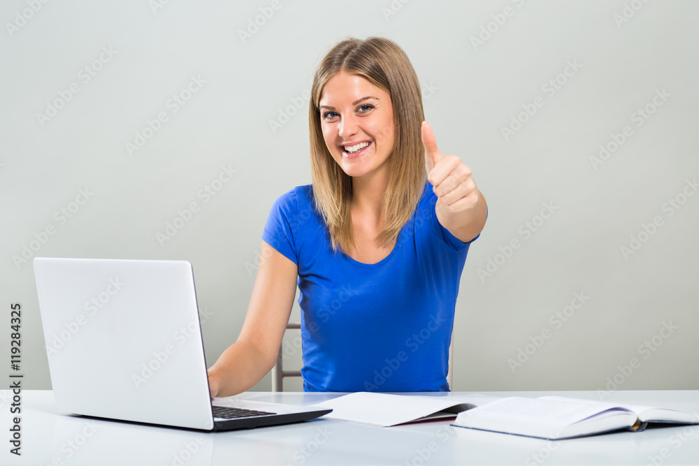Beautiful female student using laptop,studying and showing thumb up.
Beautiful female student using laptop,studying and showing thumb up.