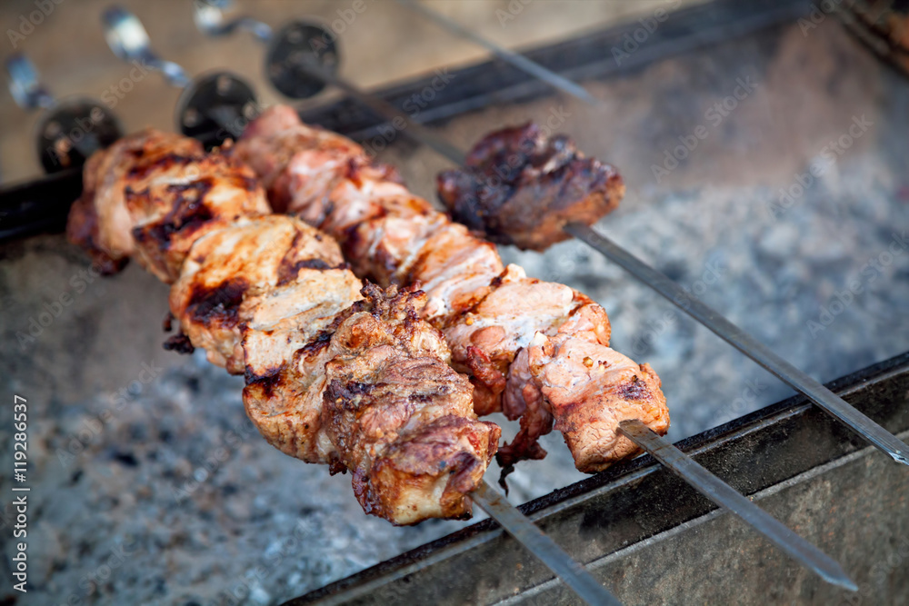 Preparation of barbecue meat shish kebab on skewers grill. Concept of lifestyle street food. Grilling traditional party picnic marinated pork beef and lamb on coal ember brazier. Preparation of barbecue meat shish kebab on skewers grill. Concept of lifestyle street food. Grilling traditional party picnic marinated pork beef and lamb on coal ember brazier.