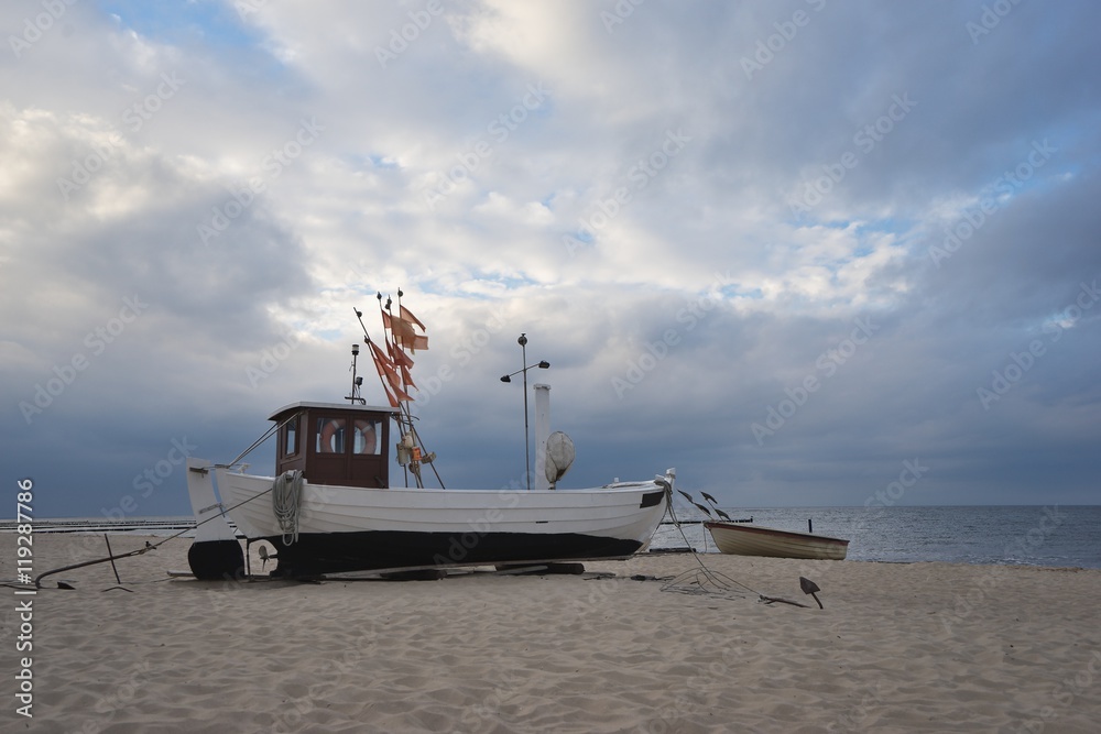 Traditional german fishing boat on the beach of Baltic sea in the sunset  before storm. Picture
