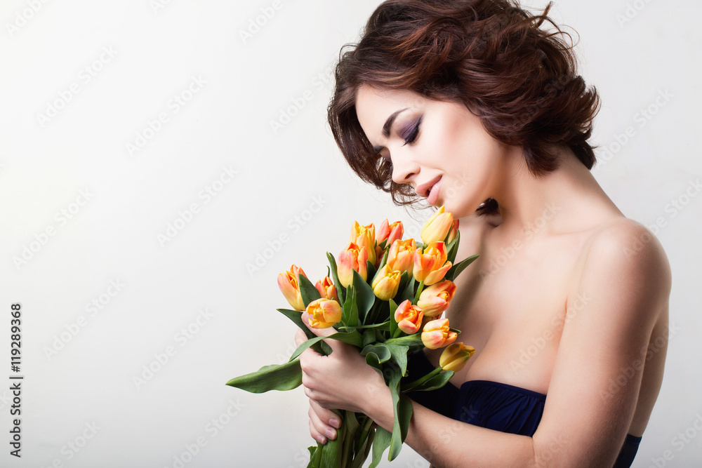 Beautiful young woman with flowers in studio.