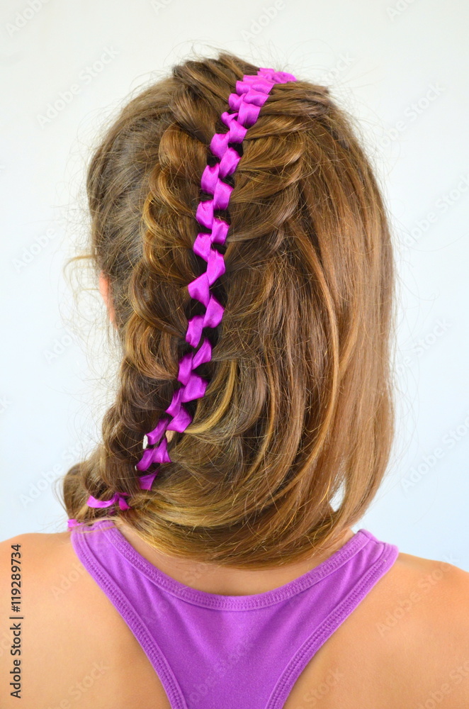 Прическа с длинных волос - вплетенная фиолетовая лента в волосах, молодая девушка на белом фоне 