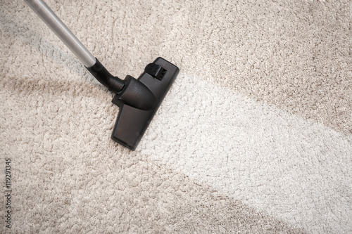 Vacuum cleaner vacuuming dusty carpet