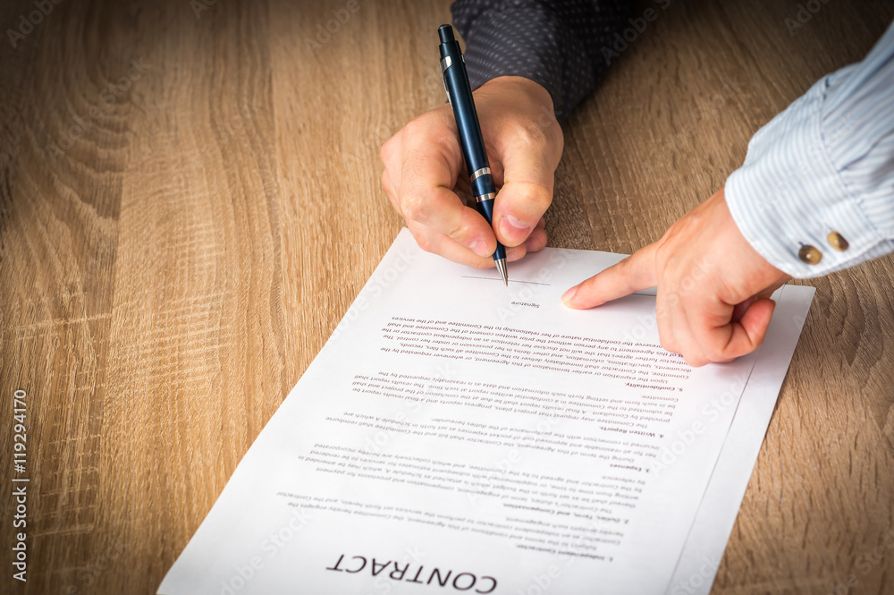 Businessman is signing a contract to conclude a deal Businessman is signing a contract to conclude a deal