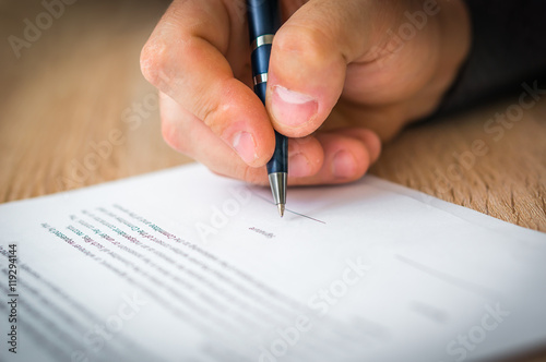 Businessman is signing a contract to conclude a deal photo