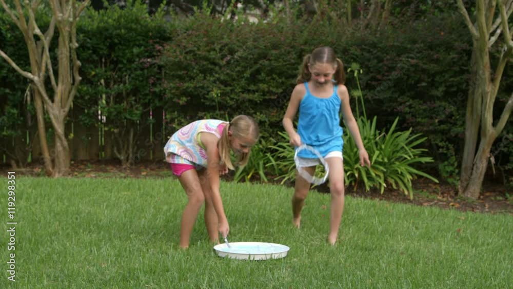 Excitement when little girls playing in their backyard successfully make a giant bubble. Excitement when little girls playing in their backyard successfully make a giant bubble.