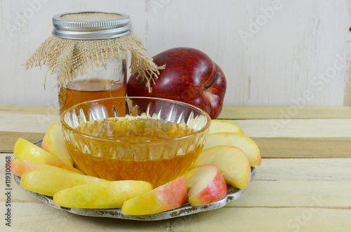 Photo Honey and apples for the Jewish New Year, Rosh Hashana on a Wooden table with wooden background