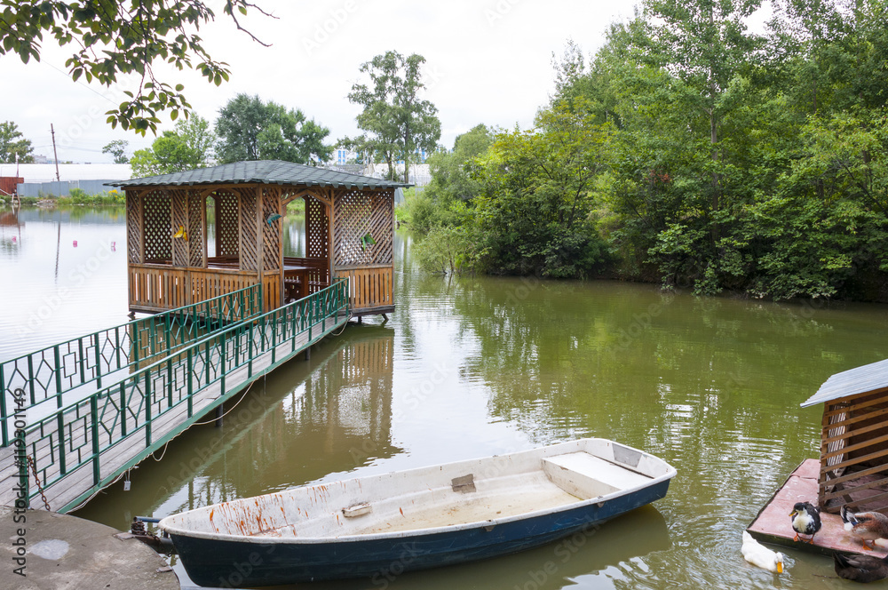 Fototapeta premium The boat on the pond next to the gazebo