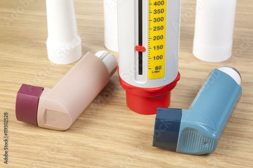 Close up of asthma inhalers and peek flow meter on table photo
