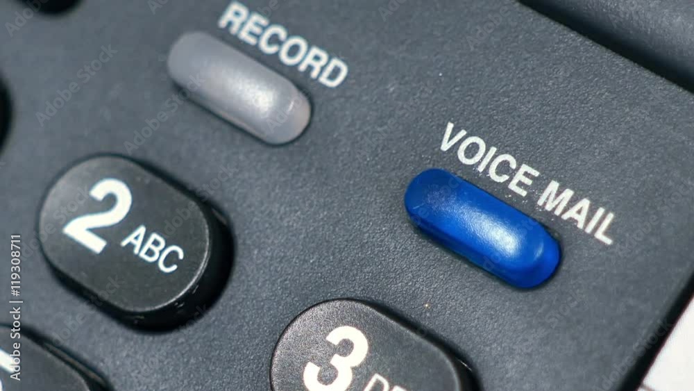 The blue blinking telephone message light on a desk phone indicating there is voice mail. The blue blinking telephone message light on a desk phone indicating there is voice mail.