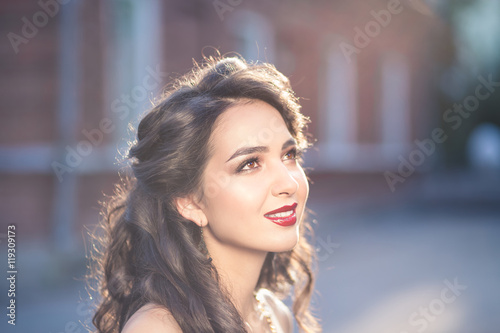 Portrait of young beautiful woman twenty five years old with dark brown or black hair outdoors on sunset. Lifestyle concept