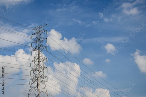 High voltage tower and electric line over cloudy blue sky in Thailand