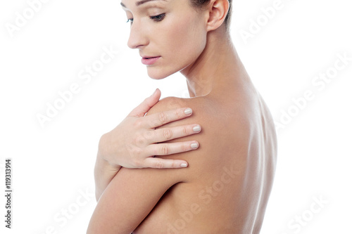 Young spa lady touching her shoulder.
