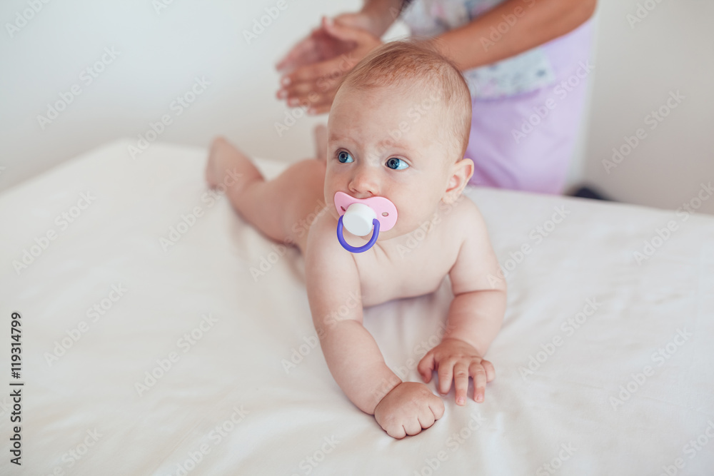 Woman doing exercises and massage the baby Woman doing exercises and massage the baby