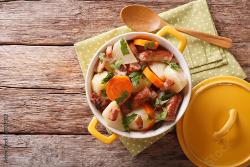 Traditional Irish dish is coddle with sausages, bacon and vegetables. Horizontal top view
