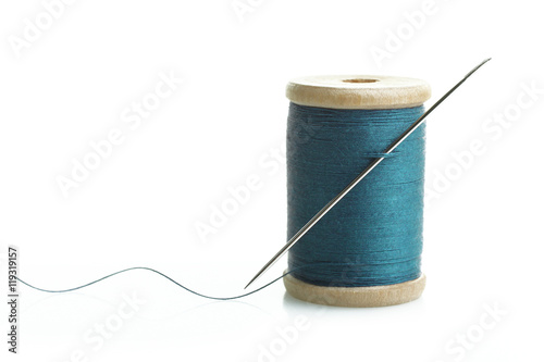 Slika na platnu Spool of thread with needle on isolated white background