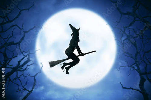 Silhouette of witch woman riding magic broom