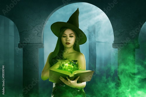 Asian witch woman holding the  book of magic photo