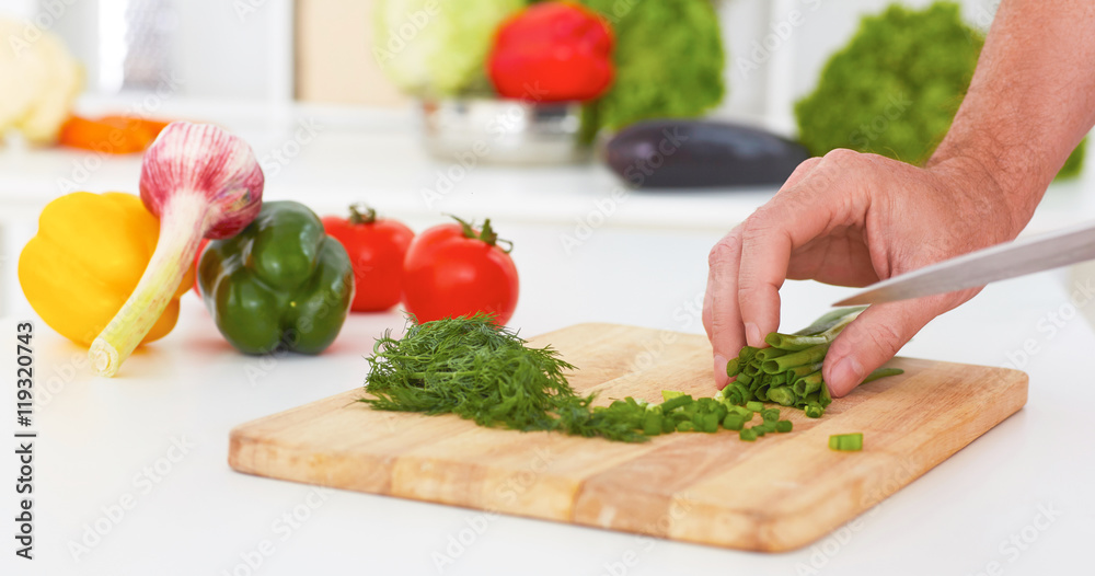 Hands of man is cooking vegetable salad in the kitchen. Hands of man is cooking vegetable salad in the kitchen.
