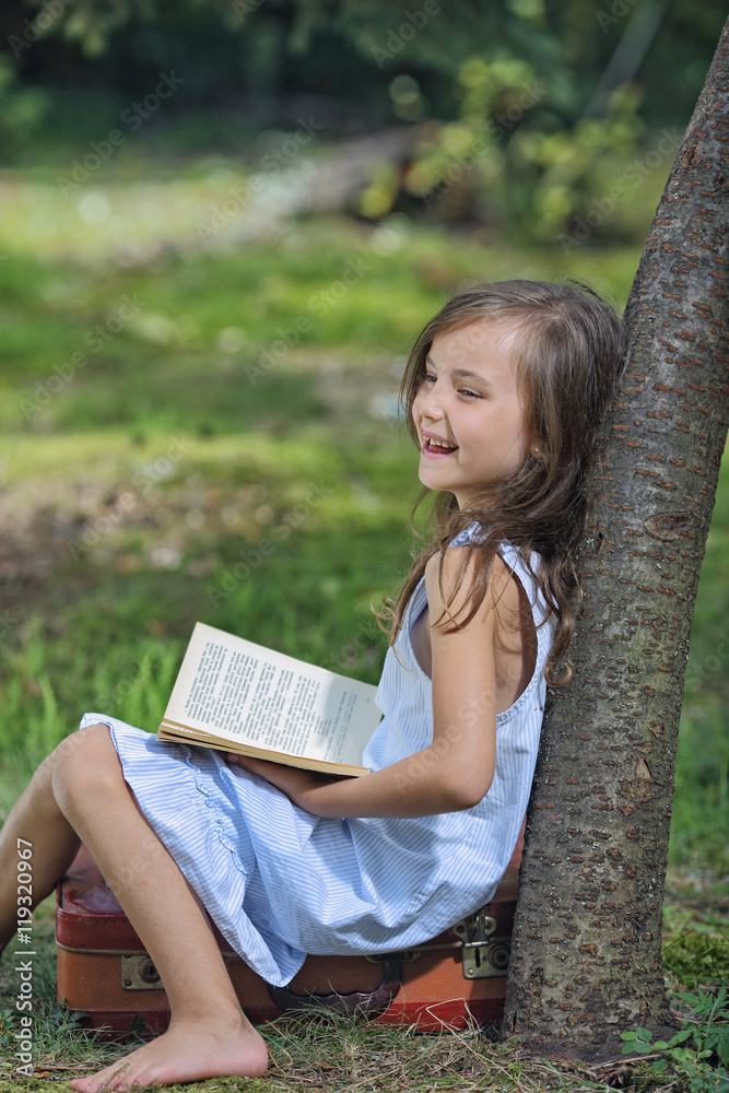 Naklejka premium Young girl experiencing positive emotions by reading a book