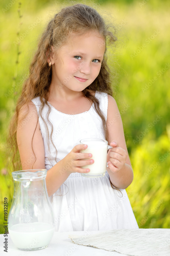 Close up portrait little girl holding glass of milk outdoor summer