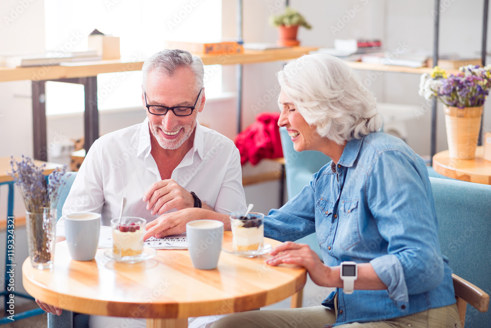 Positive senior couple reading newspaper Positive senior couple reading newspaper