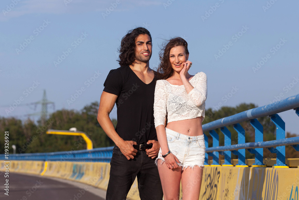 Obraz premium Young attractive couple standing on a bridge