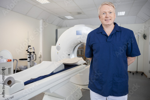 Radiologist In Uniform Standing By MRI Machine