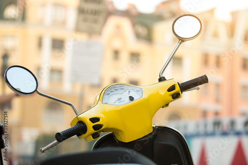 Steering wheel of yellow scooter. Mirrors and speedometer. Transport for fast trip. How to save fuel.