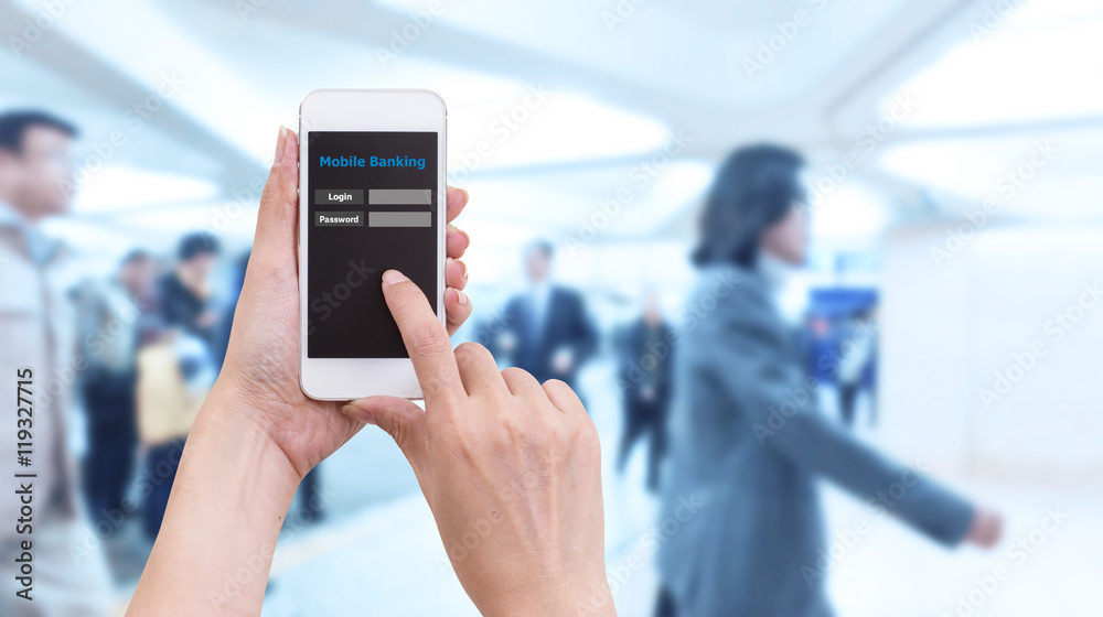 Hand holding smartphone with Mobile Banking login screen on blur