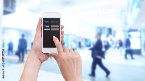 Hand holding smartphone with Mobile Banking login screen on blur