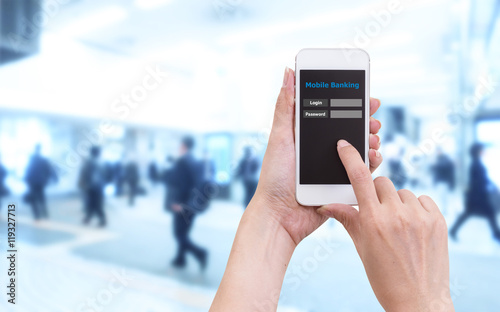 Hand holding smartphone with Mobile Banking login screen on blur