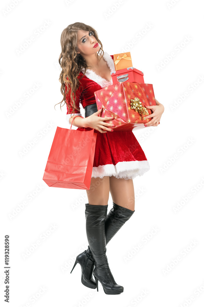 Tired Santa woman carrying many gift boxes looking at camera. Full body length portrait isolated over white studio background. Tired Santa woman carrying many gift boxes looking at camera. Full body length portrait isolated over white studio background.