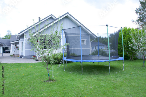 Blue trampoline on the lawn in garden