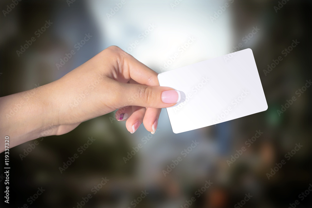 Female hand with manicure holding card isolated on blur background Female hand with manicure holding card isolated on blur background