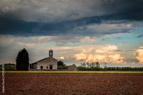 Storm reaching a little church in the fields