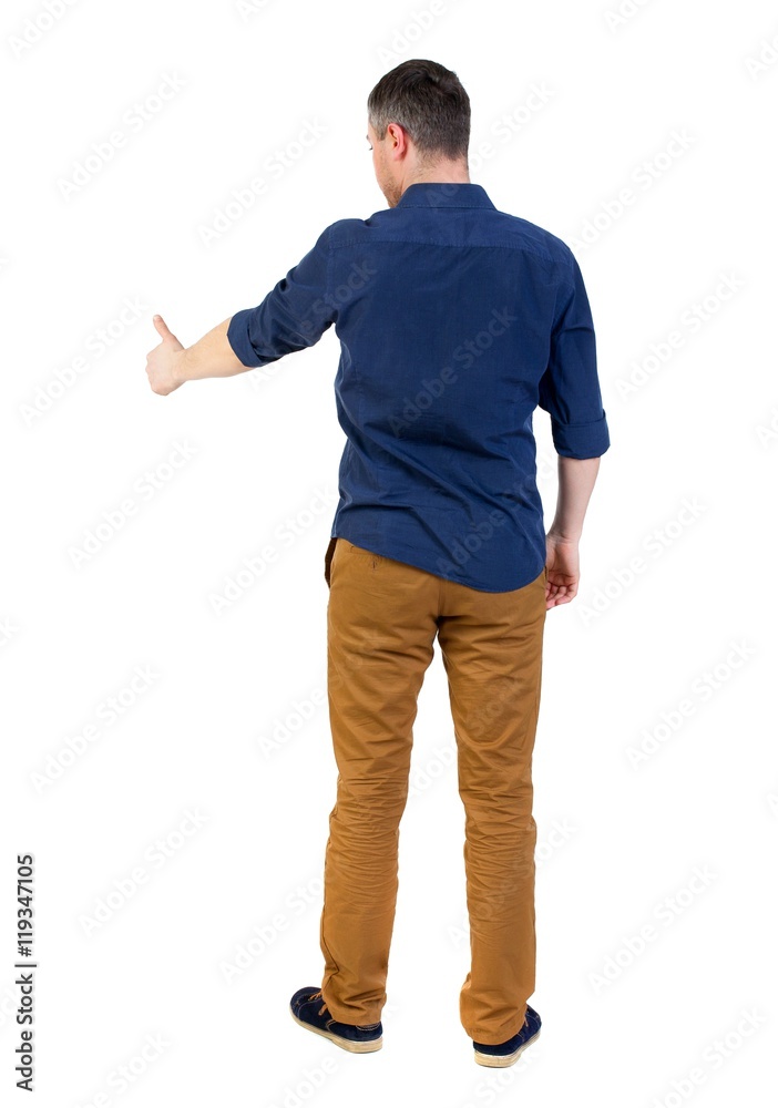 Back view of business man shows thumbs up. man in a blue shirt with the sleeves rolled up showing the right hand thumb up. Back view of business man shows thumbs up. man in a blue shirt with the sleeves rolled up showing the right hand thumb up.